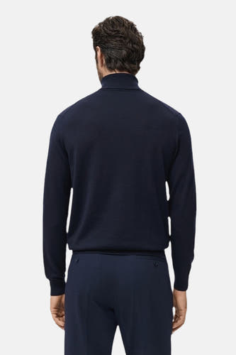 T-shirt bleu avec col rond de MANGO, vu par derrière, associé à un pantalon bleu marine.