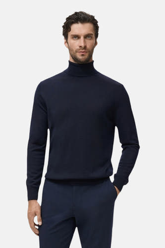 T-shirt à col rond bleu de MANGO, avec des manches longues et un design simple, associé à un pantalon bleu marine.