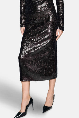 Lange bruine rok van MANGO, met pailletten en gecombineerd met zwarte pumps.