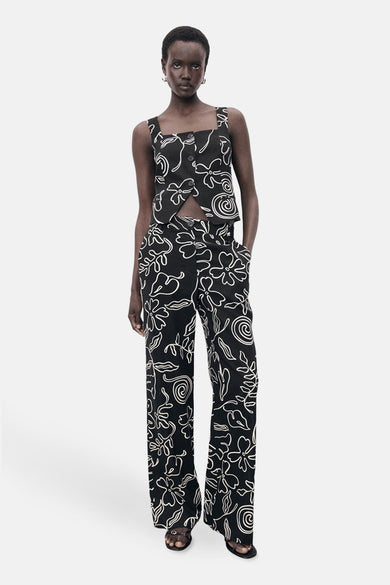 Pantalon noir avec imprimé MANGO, doté d'un motif de fleurs blanches et de vagues.
