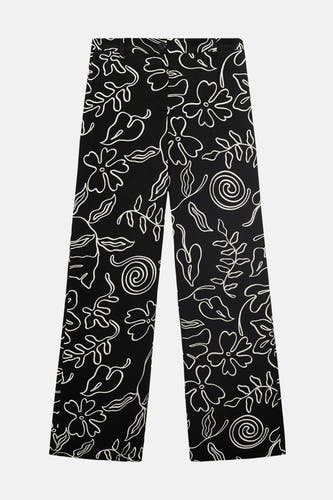 Pantalon noir de MANGO avec imprimé de fleurs et de feuilles blanches.