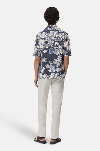 Chemise bleue à manches courtes de MANGO, avec un imprimé floral et associée à une légère jupe.