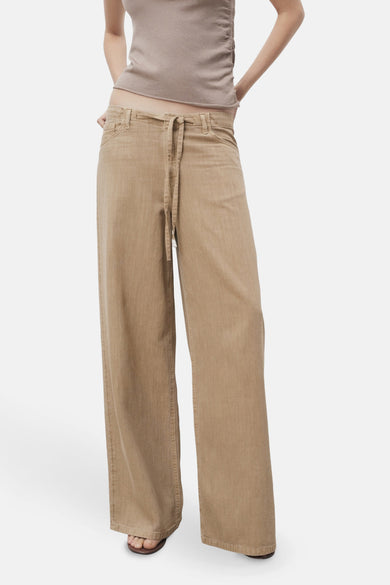 Jean beige de MANGO, avec une ceinture et des jambes larges.