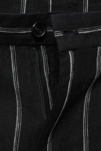 Short noir de MANGO avec une ligne de crayon et un boutonnage à glissière, détail en nœud.