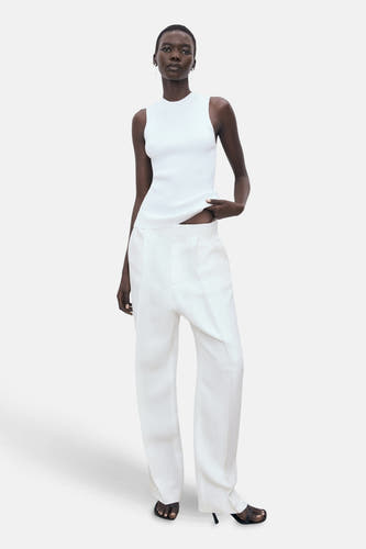Witte singlet van MANGO, gedragen met een witte pantalon en zwarte hakken.