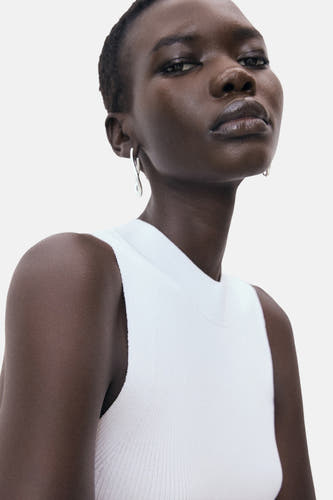 T-shirt blanc de MANGO, avec une texture côtelée et des oreilles d'argent.