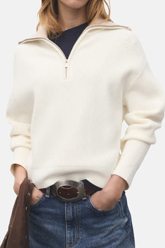 Mangue trui de MANGO avec une fermeture à glissière courte et portée avec une ceinture et du jeans.