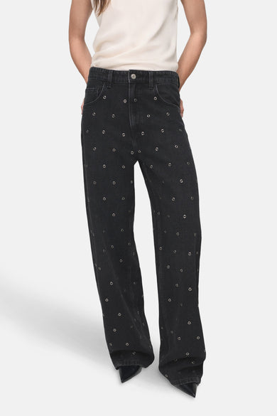 Jean denim gris foncé à larges jambes de MANGO, avec des yeux métalliques décoratifs.