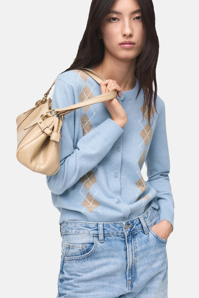 Gilet bleu de MANGO, avec un motif carreaux d'Écosse, porté sur un pantalon en denim bleu clair et une une mainche beige.