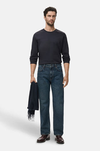 T-shirt noir à manches longues de MANGO, porté avec des jeans et des chaussures en cuir.