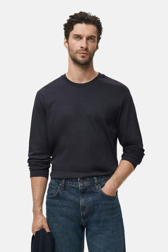T-shirt noir à manches longues de MANGO, associé à un jean bleu.