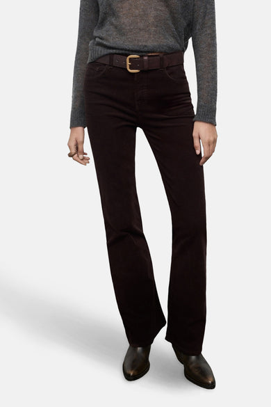 Pantalon marron de MANGO, modèle à jambes larges avec poches arrière, associé à une blouse grise.