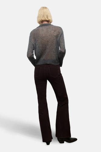 Bruine broek van MANGO, uitlopend model met achterzakken, gecombineerd met een grijze blouse.
