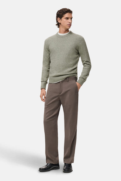 Groene trui met ronde hals van MANGO, gedragen met bruine pantalon en zwarte leren schoenen.