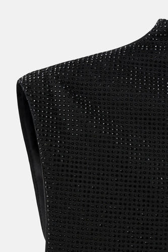 Blouse sans manches noire de MANGO, avec de petits strass noirs et un fini lisse.