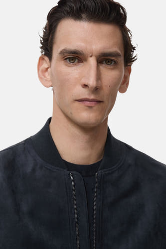 Manteau court bleu de MANGO, avec une texture lisse et un col montant.