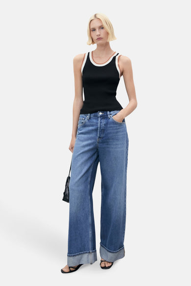 T-shirt noir de MANGO, avec des détails blancs et marrons le long de la ligne du col, associé à un jean.