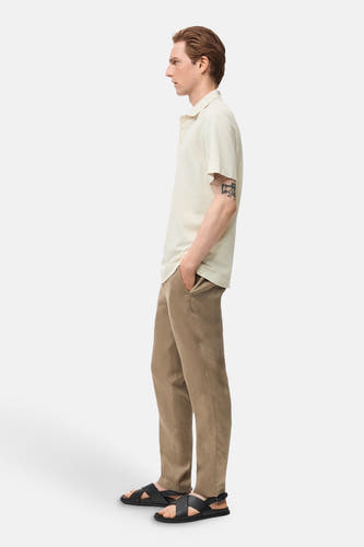 Polo écru à manches courtes de MANGO, avec un pantalon marron et des sandales noires, en vue latérale.