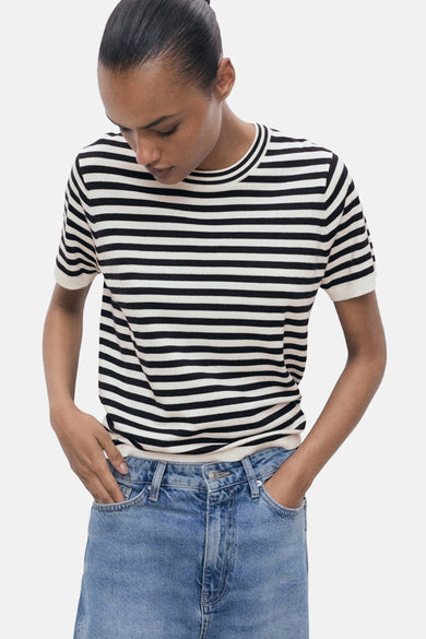 T-shirt multicolore à manches courtes de MANGO, avec un motif rayé horizontal et associé à un jean bleu.