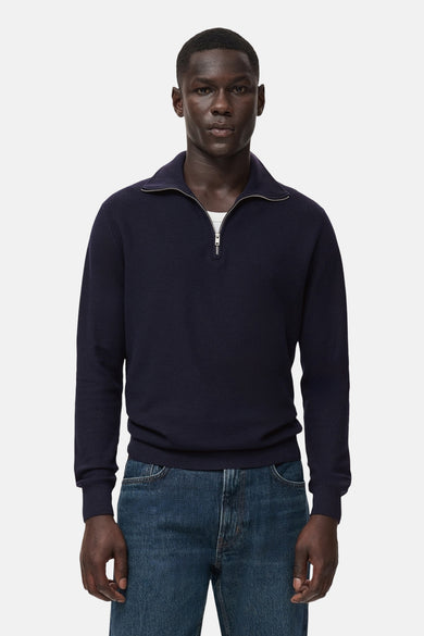 T-shirt bleu avec col montant de MANGO, doté d'une fermeture éclair courte et associé à un jean.