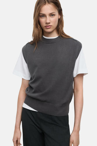 T-shirt gris MANGO, associé à un T-shirt blanc et à un pantalon sombre avec des rayures blanches.