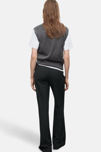 T-shirt gris MANGO porté sur un T-shirt blanc, avec un pantalon noir à rayures blanches.