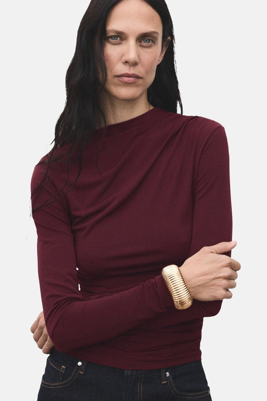 T-shirt bordeaux avec longues manches de MANGO, à col rabattu et associé à un bracelet doré.