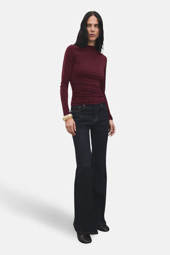 T-shirt Bordeaux à manches longues de MANGO, porté avec des jeans larges et un bracelet en or.