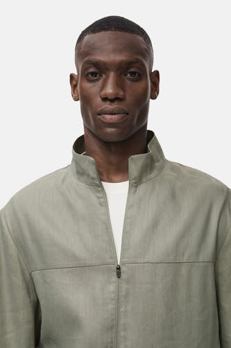 Manteau court vert de MANGO, avec col montant et fermeture à glissière devant.