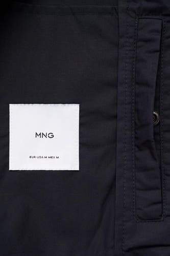 Manteau court bleu de MANGO avec étiquette de marque et détail de poche.