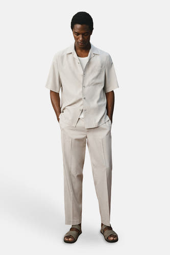 Pantalon écru de MANGO, avec une légère texture et une coupe décontractée et droite.