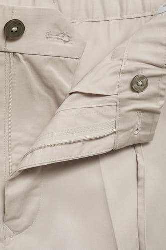 Pantalon écru de MANGO avec fermeture éclair et boutons, gros plan.