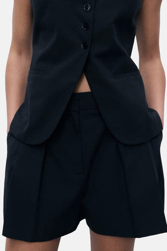 Shorts noirs de MANGO, avec plis à l'avant et poches.