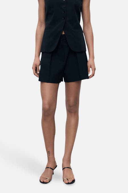 Shorts noirs de MANGO, avec plis et poches sur les côtés.