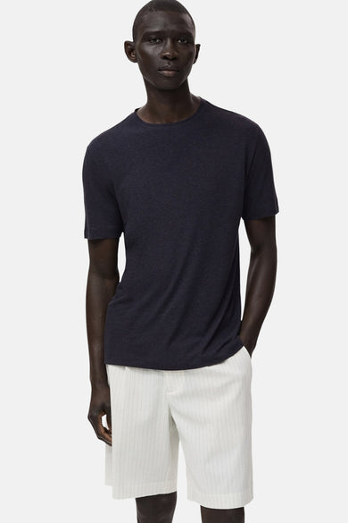 T-shirt noir à manches courtes de MANGO, porté avec un short rayé.