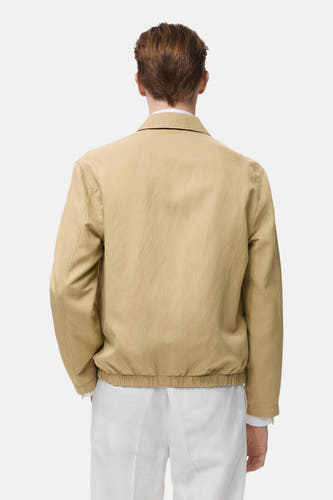 Manteau beige court de MANGO, avec des manches longues, un élastique et une encolure, vue arrière.