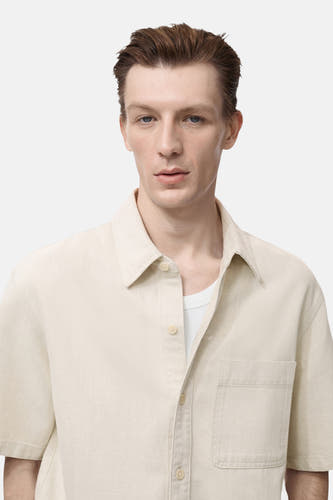 Chemise en jeans écru de MANGO, à manches courtes et avec une poche po.