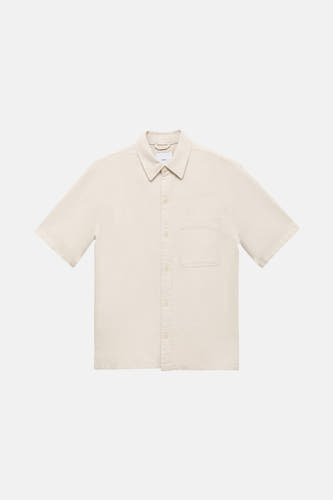 Chemise en jeans écru de MANGO, à manches courtes et avec une poche po.