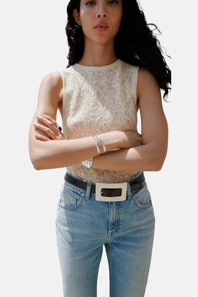 Top écru sans manches de MANGO, avec un motif de feuille fin et subtil, combiné à des jeans et des bracelets en argent.