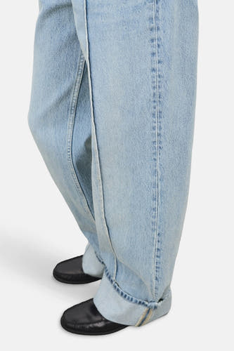 Jean droit bleu clair de MANGO, avec des poches rabattues et des chaussures noires.