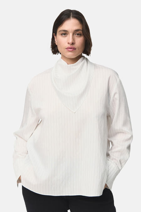 Blouse blanche à longues manches de MANGO, avec des rayures verticales subtiles et une coupe décontractée.