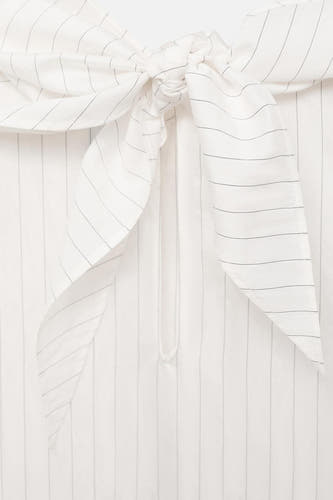 Blouse blanche à longues manches de MANGO, avec un motif rayé et des détails noués.