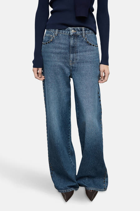 Jean denim bleu marine large de MANGO, avec des strass le long des côtés et des jambes qui s'élargissent.