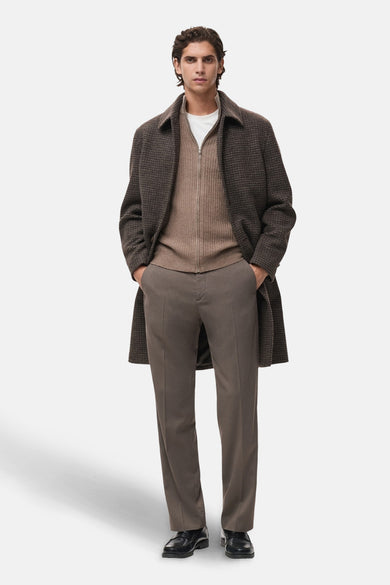 Bruin gilet van MANGO, gedragen over een wit T-shirt en gecombineerd met een bruine pantalon en zwarte schoenen.
