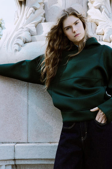 Groene sweater met kap van MANGO, met lange mouwen, een rechte pasvorm en donkere jeans.
