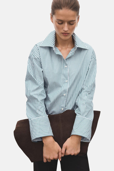 Chemise rayée verte de MANGO avec des manches longues, un col classique et une fermeture à boutons, associée à une sac marron.