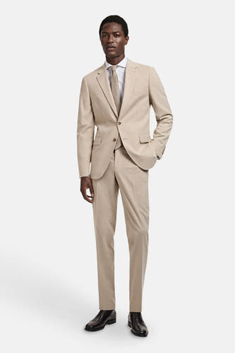 Blazer beige de MANGO, avec une pantalon coordonné, un chemise blanche et une cravate marron.