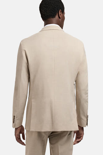Blazer beige de MANGO, vu de van lrière, avec une texture lisse et des boutons subtils sur les manches.
