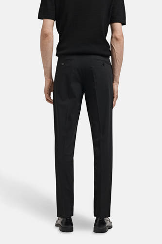 Pantalon de costume noir MANGO, vu de l'arrière, combiné avec un shirt noir et des chaussures noires.