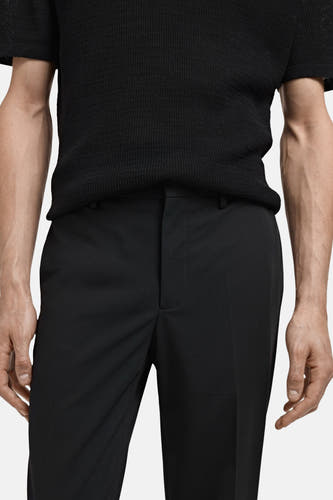 Pantalon de costume noir MANGO, avec une texture lisse et une coupe classique.